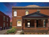 Charming brick home featuring a cozy front porch and well-maintained landscaping at 1021 E 23Rd Ave, Denver, CO 80205