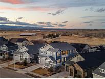 Stunning aerial view of a residential neighborhood with mountain views at sunset at 7895 Julsburg Cir, Littleton, CO 80125