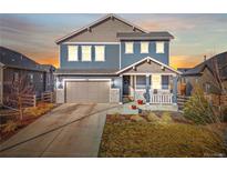 Charming two-story home with a front porch, blue siding, and a two car garage at 7895 Julsburg Cir, Littleton, CO 80125
