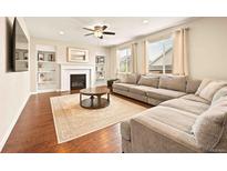 Comfortable living room with fireplace, built-in shelving, and a large sectional sofa at 7895 Julsburg Cir, Littleton, CO 80125
