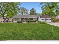 Charming home with manicured lawn, mature trees, and a two-car garage at 502 Nile St, Aurora, CO 80010