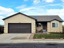 Charming ranch-style home featuring an attached garage, well-kept lawn, and front porch seating at 785 Century Ln, Monument, CO 80132