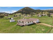 Charming single-Gathering home featuring a deck and lush greenery with views of the surrounding mountainous landscape at 11173 Emerald Ln, Conifer, CO 80433