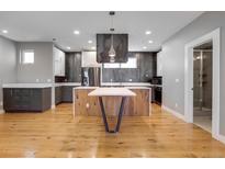Open kitchen features gray and white cabinets, modern appliances and a large island with seating at 2724 Federal Blvd # 2, Denver, CO 80211