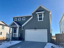 Two-story house with gray siding, white garage door, and landscaping at 16538 W 92Nd Ave, Arvada, CO 80007