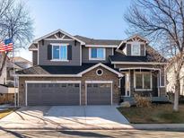 Charming two-story home featuring a three-car garage and a mix of stone and gray siding at 9595 S Everett Way, Littleton, CO 80127