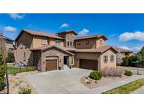 Stunning two-story home featuring a tile roof and stone accents with a spacious three car driveway at 15205 W Iliff Ave, Lakewood, CO 80228