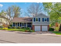 Charming two-story home with a well-manicured lawn, blue shutters, and an attached two-car garage at 6918 E Easter, Centennial, CO 80112