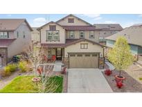 Inviting two-story home featuring a front porch, well-maintained lawn, and an attached two-car garage at 7763 S Elk St, Aurora, CO 80016