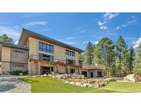 Beautiful two-story home with a landscaped yard, a private putting green, a balcony, and an attached garage at 7793 Elk Path Way, Morrison, CO 80465