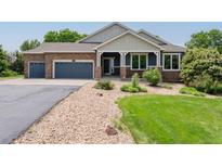 Charming home featuring a stone facade, covered porch, and well-maintained gravel and grass landscaping at 7126 E 162Nd Ct, Brighton, CO 80602