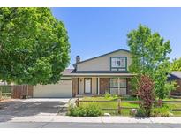 Charming two-story home featuring a well-manicured lawn, brick accents and attached two car garage at 1584 S Fraser Way, Aurora, CO 80012