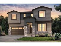 Charming two-story home featuring a stone pillar front porch, complemented by lush landscaping and an attached two car garage at 3818 N Duquesne St, Aurora, CO 80019