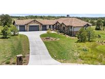 Stunning home boasts a long driveway, three-car garage, and lush landscaping at 8625 Eagle Moon Way, Parker, CO 80134