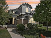 Inviting two-story home with gray siding, brick accents, and manicured landscaping in a desirable neighborhood at sunset at 25548 E Fair Dr, Aurora, CO 80016