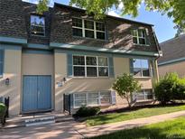 Two story condominium building with a tan brick facade, blue trim, and well-manicured lawn at 9440 E Girard Ave # 1, Denver, CO 80231