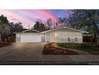 Charming single-story home with a well-manicured lawn, attached garage, and delightful curb appeal at dusk at 712 S Longmont Ave, Lafayette, CO 80026