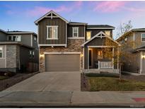 Beautiful two-story home with stone accents, manicured lawn, and a spacious two-car garage with a large drive way at 1031 White Leaf Cir, Castle Rock, CO 80108
