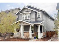 Charming two-story home features a covered porch, stone accents, and a well-maintained landscaped front yard at 5488 N Xenia St, Denver, CO 80238