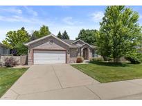 Charming brick home with a well-manicured lawn and an attached two-car garage at 329 Bobcat Pt, Lafayette, CO 80026