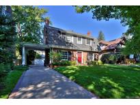 Charming brick home with a well-manicured lawn and vibrant red front door at 2035 Bellaire St, Denver, CO 80207