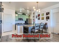 A stylish eat-in kitchen features mint-green cabinets, a subway tile backsplash, and a pendant light over the dining area at 4100 Albion St # 221, Denver, CO 80216
