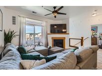 Bright living room featuring a modern fireplace, plush sectional sofa, and balcony access at 4100 Albion St # 221, Denver, CO 80216