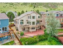 Stunning backyard view of a two-story home featuring dual wood balconies and a red-tiled patio, perfect for outdoor entertaining at 165 Washington St, Golden, CO 80403