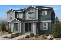 Charming two-story townhome featuring a stylish exterior with gray and blue siding and decorative shutters at 2194 Farm Fresh Aly, Brighton, CO 80601
