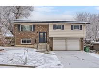 Inviting two-story home with brick and siding, featuring a two-car garage and snowy front yard at 8351 Ralph Ln, Denver, CO 80221