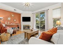 Cozy living room with a fireplace, balcony access, and stylish decor creating an inviting space at 2169 Eagle Ave # 2169, Superior, CO 80027