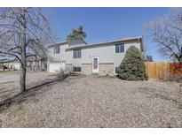 Charming multi-level home with neutral siding and a well-maintained front yard in a quiet neighborhood at 15541 E Cornell Ave, Aurora, CO 80013