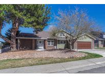 Charming home featuring mature landscaping, brick accents, and a welcoming front entrance, creating inviting curb appeal at 7444 S Milwaukee Ct, Centennial, CO 80122