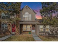 Evening view of charming two-story townhome with landscaping at 9691 W Chatfield Ave # E, Littleton, CO 80128
