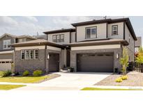 Modern two-story home featuring a combination of brick and siding, two-car garage, and well-manicured landscaping at 6506 Barnstead Dr, Castle Pines, CO 80108