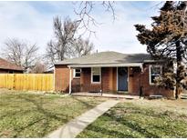 Charming brick home featuring a well-manicured lawn and inviting front porch at 3993 Haddon Rd, Denver, CO 80205