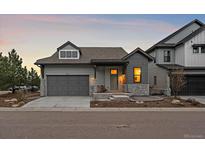 Charming single Gathering home with gray exterior, stone accents, and a two-car garage at 7010 Homeplace Pt, Castle Rock, CO 80108