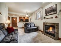 Inviting living room featuring a cozy fireplace and comfortable seating, seamlessly connected to the kitchen at 34 Highfield Trl # 112, Breckenridge, CO 80424