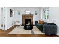 Bright living room featuring a brick fireplace, modern sofa, and stylish decor at 4003 Federal Blvd, Denver, CO 80211