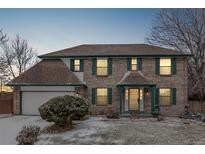 Charming two-story home with a brick facade, green trim, and a well-manicured front yard at 12107 E Vassar Dr, Aurora, CO 80014