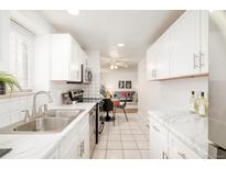 Bright kitchen features white cabinets, stainless steel appliances, and access to dining and living spaces at 1243 N Washington St # 108, Denver, CO 80203