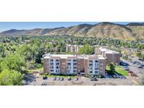Apartment complex with mature trees, a parking lot, and views of the Colorado mountains in the background at 1150 Golden Cir # 409, Golden, CO 80401