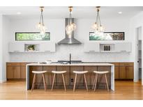 Bright kitchen featuring pendant lighting, a center island, and white and wood cabinets at 1241 S Garfield St, Denver, CO 80210