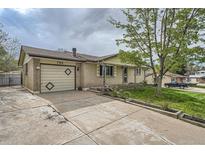 Charming single-story home with a brick facade, well-manicured lawn, and an attached garage at 755 Braun St, Lakewood, CO 80401