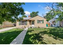 Charming single-story home with a well-manicured lawn, walkway, and inviting front door at 1049 Galena St, Aurora, CO 80010