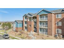 Charming condo building featuring brick facade, balconies, and well-maintained landscaping at 2705 S Danube Way # 101, Aurora, CO 80013