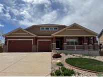 Charming two-story home featuring a covered porch, a two-car garage, and a well-manicured front yard at 1100 Columbine Way, Erie, CO 80516