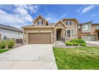 Charming two-story home with a well-manicured lawn and inviting stone accents at 6335 E 143Rd Dr, Thornton, CO 80602