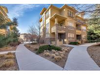Beautiful townhouse with stone accents, balconies, manicured landscaping, and winding walkways at 7887 Vallagio Ln, Englewood, CO 80112