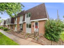 Two-story brick townhouse with flower bed in front at 12956 W Virginia Ave, Lakewood, CO 80228